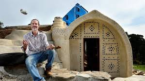 WELCOME to Martin Freney’s new home. It’s built from earth-filled tyres, bottles and straw barrels, uses solar power, rainwater and recycled sewage and just might be the future of Australian housing. The University of South Australia lecturer is adding the finishing touches to his fully sustainable “Earthship” home, the first of its kind in Australia. The council-approved home runs off the grid of public utilities companies and uses no fossil fuels for power, instead harnessing solar energy and thermal ventilation principles to regulate inside temperature. His Earthship, a 30-minute drive from Adelaide, has taken five years to build and aside from a few minor features has been constructed purely with the help of volunteers. Mr Freney said he built the home to expose Australians to the Earthship concept, a house design invented in the US by architect Michael Reynolds. “It’s a wonderful solution to many of our modern problems,” Mr Freney said. “Earthships are made only from natural or recycled materials and draw nothing from local water or power sources. They require no conventional heating but are comfortable in any weather. It could be minus 20 outside and you wouldn’t know.” Mr Freney’s home is designed for two people and includes all the features of a standard house, along with a hot tub and a walk-in wardrobe behind a dry mud wall infused with used bottles. Toilets are flushed with filtered sink, shower and bath water, which also irrigates food-producing plants in the home’s greenhouse. Drinking water is collected off the roof, which channels rainwater into a cistern. Sewage water is sent to a septic tank for cleaning and later used to water the nearby landscape. Although electricity is derived from solar panels and stored in batteries, Mr Freney said little power was needed. “The idea behind the tyre and earth walls is that they soak up heat during the day and radiate that heat at night. That’s how they stay so comfortable,” he said. Mr Freney’s home has inspired others to pursue similar projects across Australia. Earthship Biotecture Academy spokeswoman Rachel Goldlust said educating the public about Earthship build-ing concepts could lead to more.She said: “They’ve been trialled around the world and we’re hoping more Australians become interested in sustainable living”.