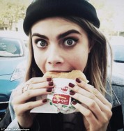 Cara Delavigne eats a burger -- beef is one of the most carbon intensive foods