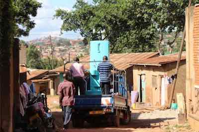 Workers bring a toilet to  remote vllage